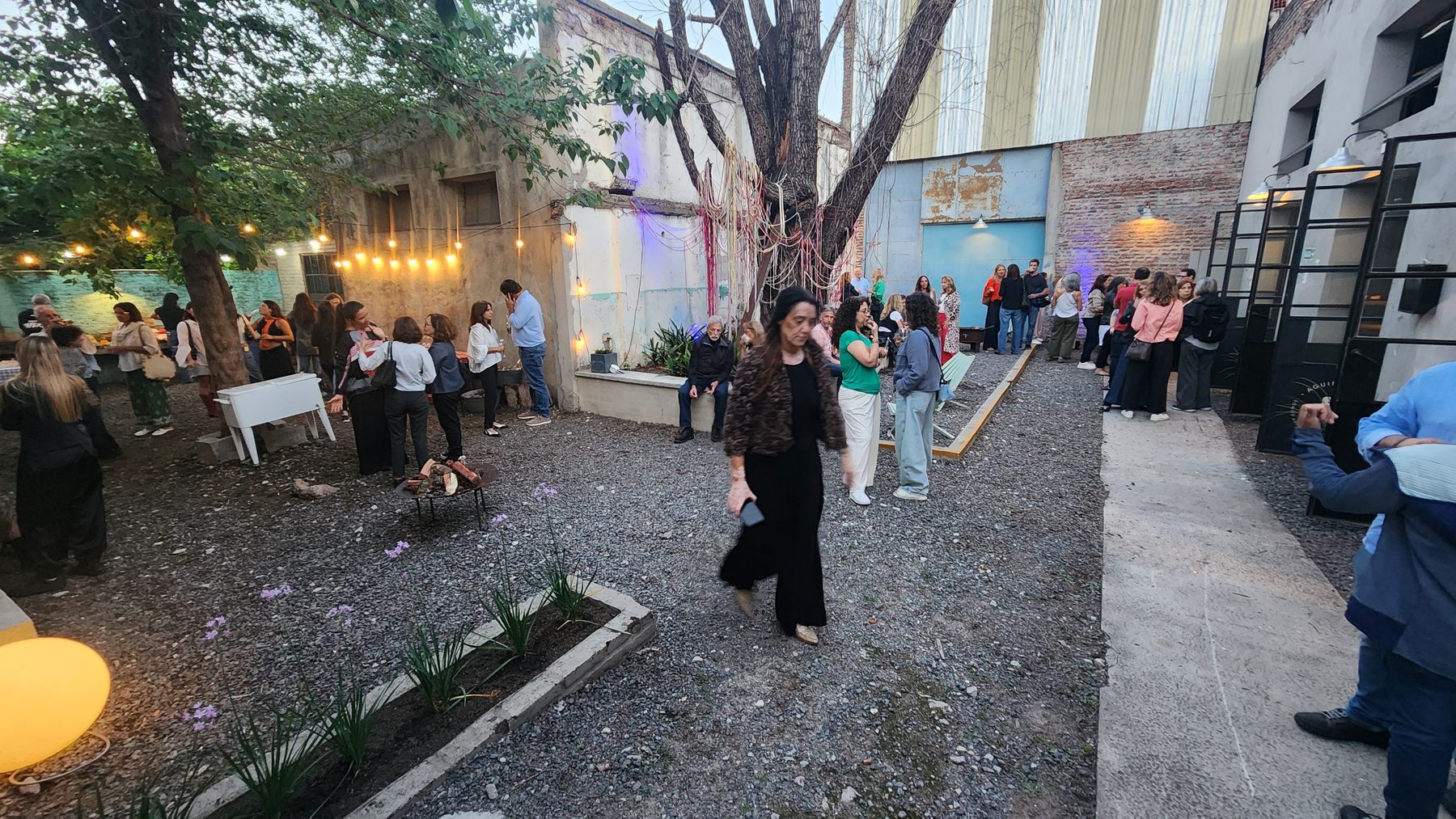 El patio del taller de noche, lleno de gente